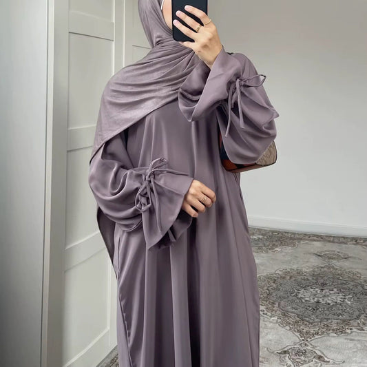 
Eine elegante, sandfarbene Abaya mit lockerer Passform und Kapuze, kombiniert mit einem passenden Hijab. Der fließende Stoff sorgt für eine stilvolle Silhouette, während der minimalistische Look modernen Komfort mit traditioneller Ästhetik verbindet. Perfekt für einen schlichten, aber edlen Modest-Fashion-Stil.